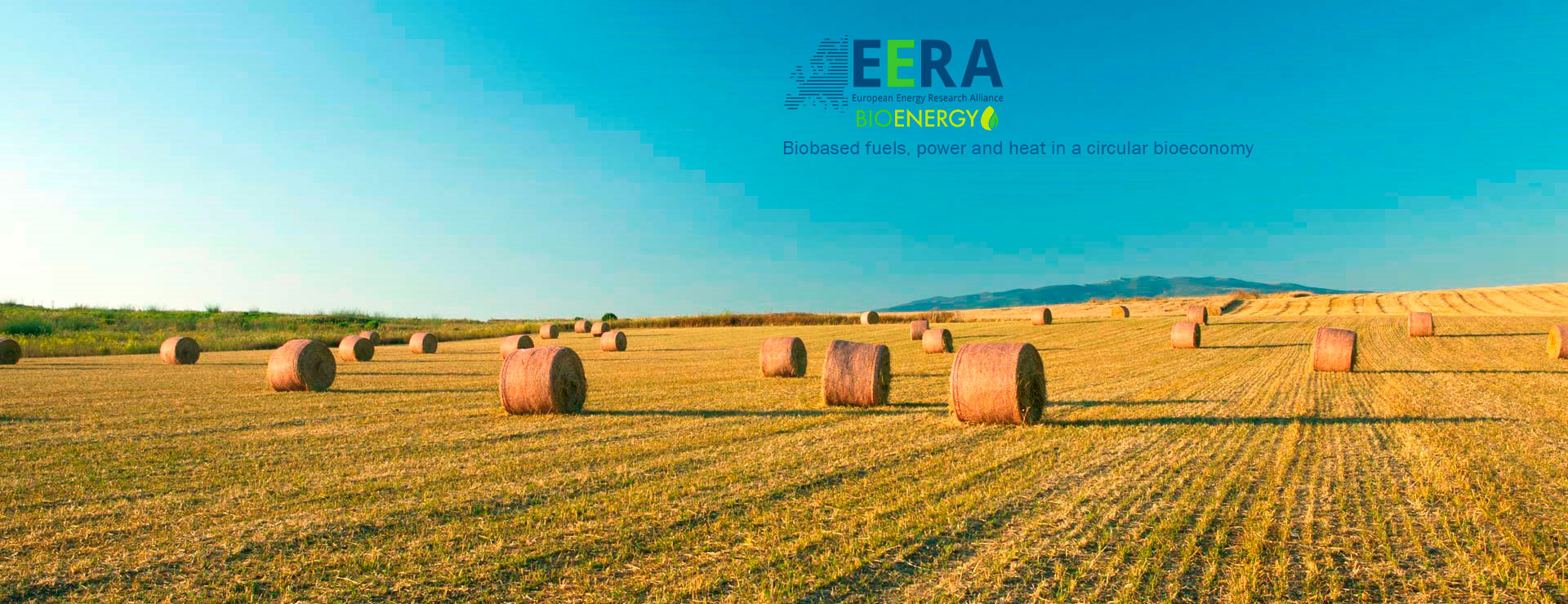 Campo agrícola con balas de paja y paisaje rural asociado a la bioenergía sostenible y la bioeconomía circular de EERA Bioenergy.